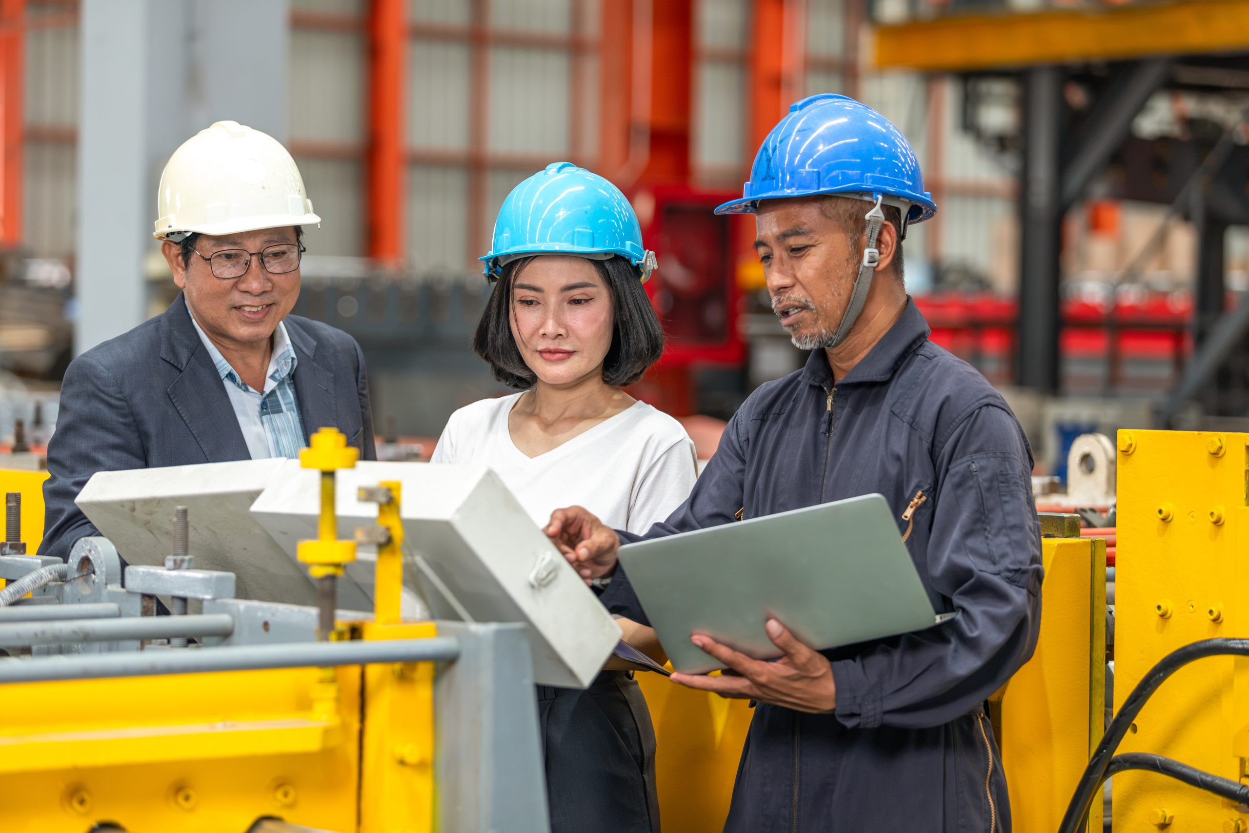 Manufacturing professionals reviewing machine information on a laptop